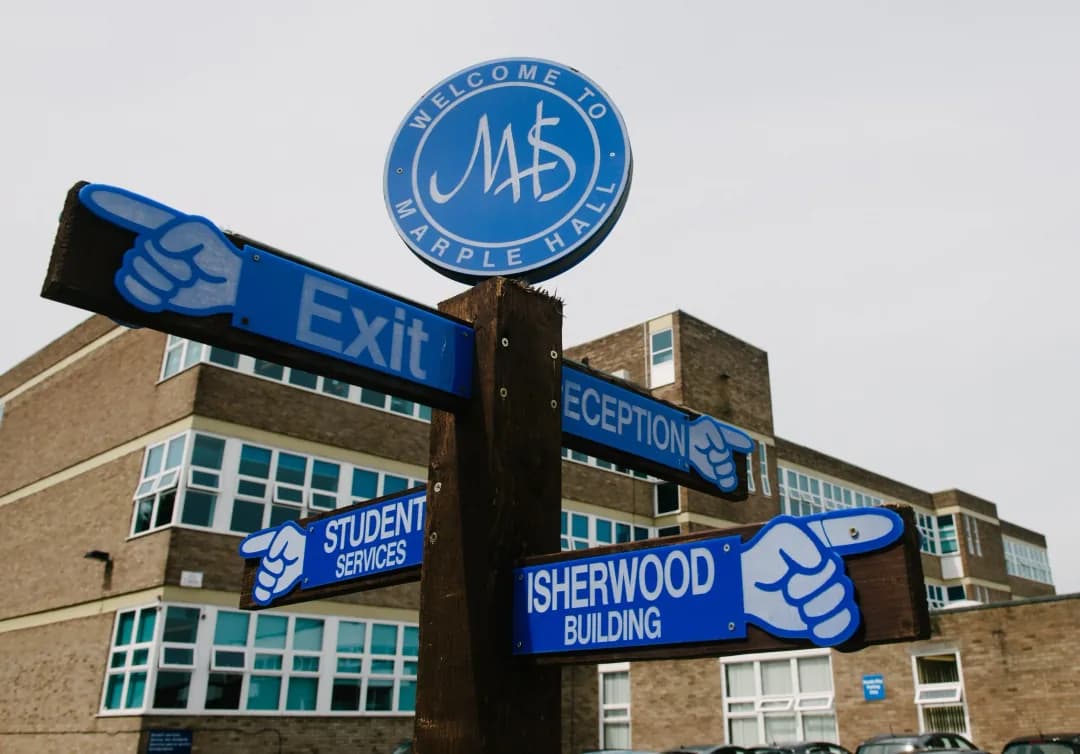 Photo of signs at Marple Hall, including Exit, Sherwood Building, Bradshaw Building and Reception.
