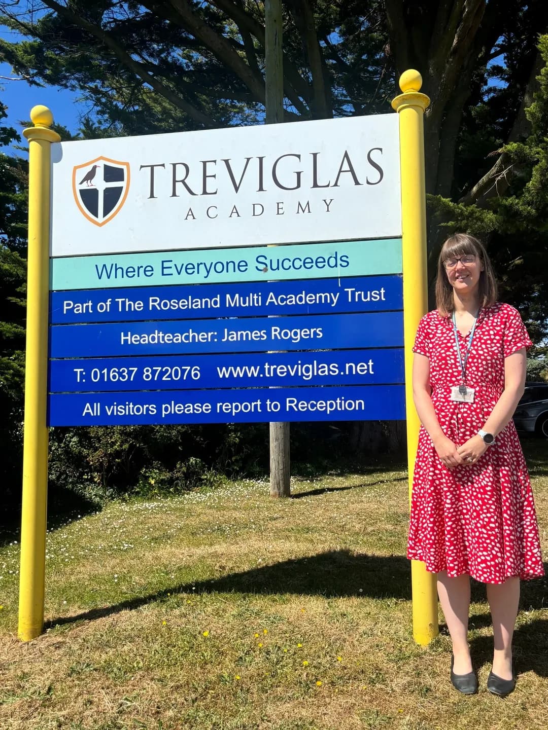 Photo of Clare Quarton, Teaching Team Leader for Humanities, next to the sign for Treviglas Academy